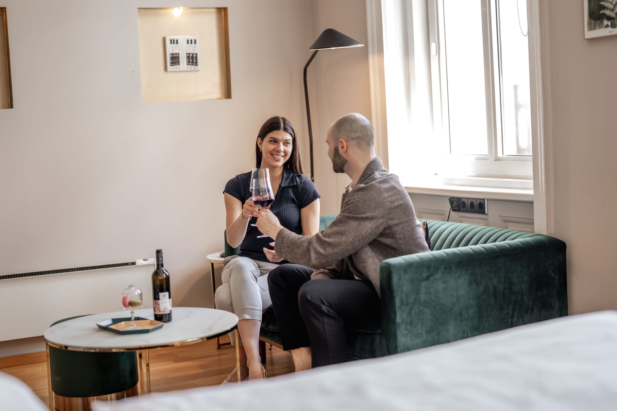 Gäste genießen ein Glas Wein in einem Zimmer des Hotel Rathaus Wein & Design in Wien
