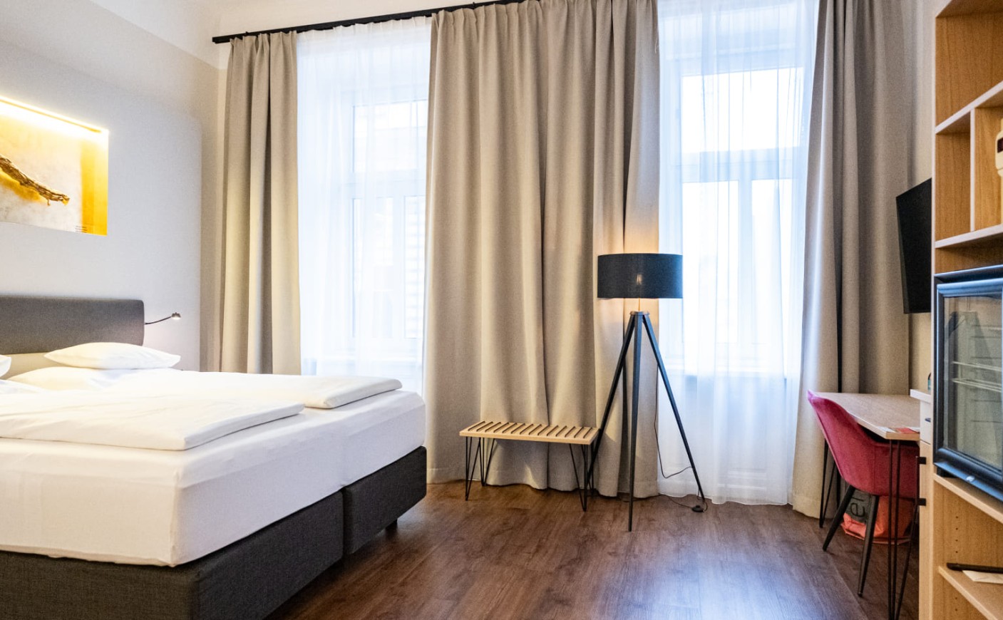 Helles Doppelzimmer Economy mit gro&szlig;en Fenstern, Sitzgelegenheit und Schreibtisch