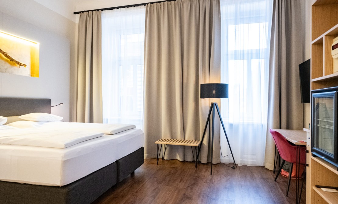 Helles Doppelzimmer Economy mit gro&szlig;en Fenstern, Sitzgelegenheit und Schreibtisch
