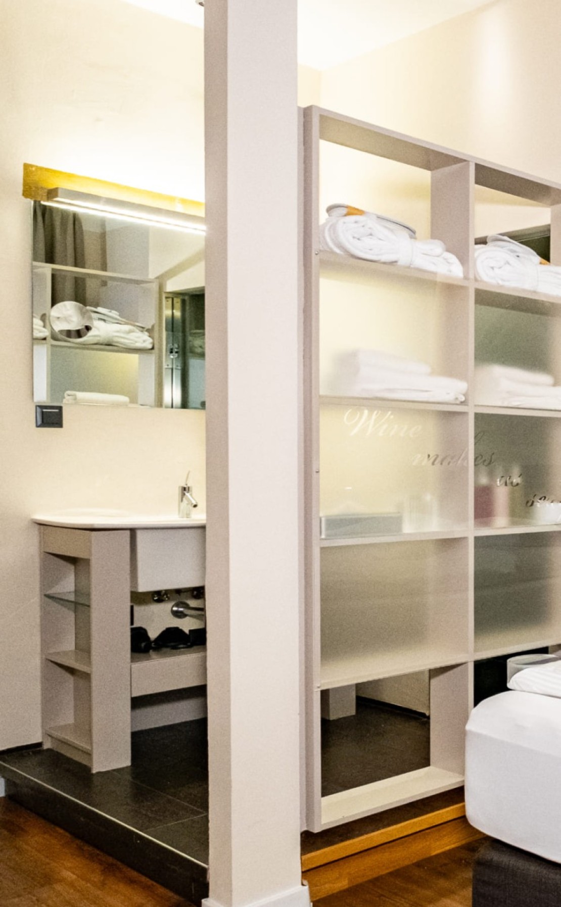 Offener Badezimmerbereich mit Waschplatz und Regalen im Doppelzimmer Economy