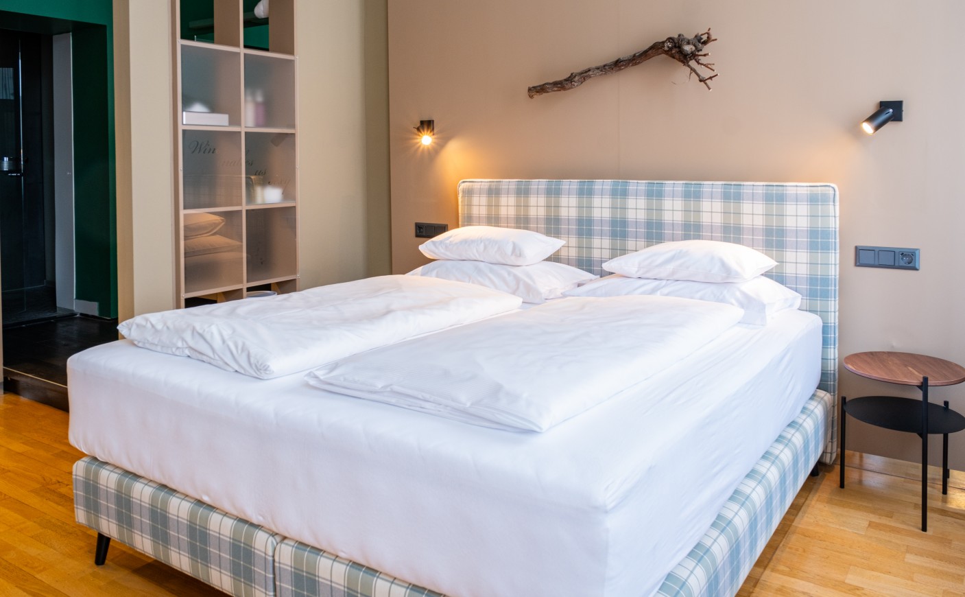 A neatly made bed with a patterned headboard in a modern bedroom