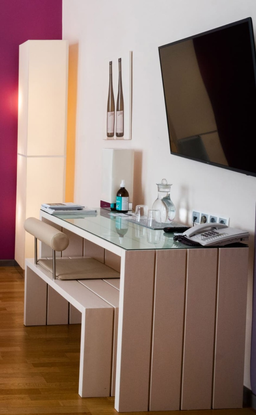 Schreibtisch mit TV und Minibar im Familienzimmer des Hotel Rathaus Wien