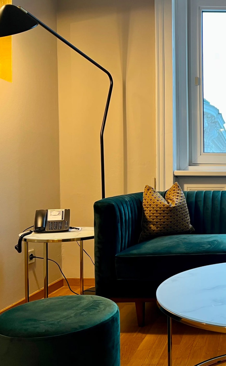 Gem&uuml;tliche Sitzecke mit Sofa und Designleuchte in der Junior Suite
