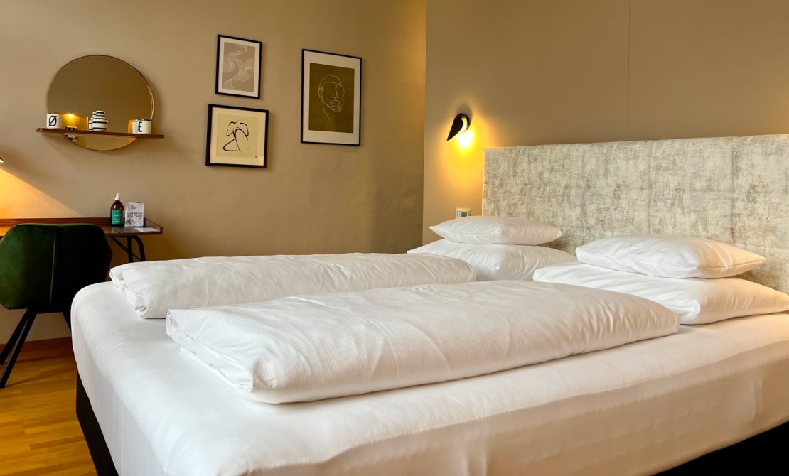 Doppelbett und wohnliches Ambiente in der Junior Suite des Hotel Rathaus Wien