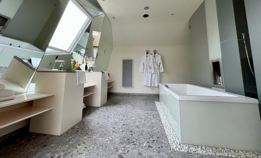 Badezimmer mit Badewanne und Dachfenstern im Hotel Rathaus